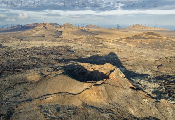 Volcán de Las Nueces volcano, picturesque volcanic landscape with volcanic craters and lava fields in morning light, Parque Natural de Los Volcanes, aerial view, Lanzarote, Canary Islands, Spain