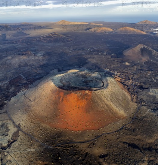 Caldera Colorada volcano, picturesque volcanic landscape with volcanic craters and lava fields in morning light, Parque Natural de Los Volcanes, aerial view, Lanzarote, Canary Islands, Spain
