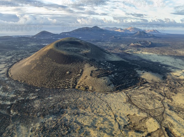 Montaña Negra volcano, picturesque volcanic landscape with volcanic crater in morning light, Parque Natural de Los Volcanes, aerial view, Lanzarote, Canary Islands, Spain