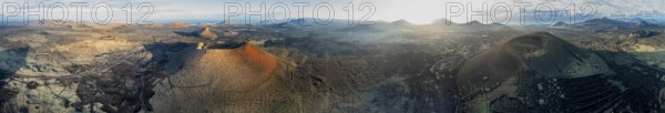 Panorama, Caldera Colorada volcano and Montaña Negra, picturesque volcanic landscape with volcanic craters and lava fields in morning light, Parque Natural de Los Volcanes, aerial view, Lanzarote, Canary Islands, Spain