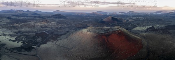Caldera Colorada volcano, picturesque volcanic landscape with volcanic craters at sunrise, Los Volcanes Natural Park, aerial view, Lanzarote, Canary Islands, Spain