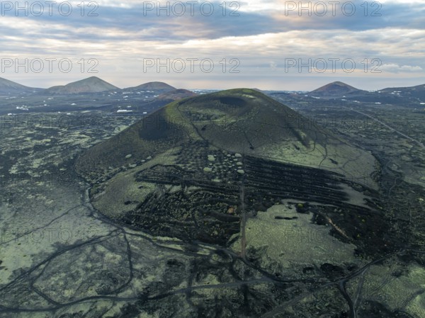 Montaña Negra volcano, picturesque volcanic landscape with volcanic crater at sunrise, Parque Natural de Los Volcanes, aerial view, Lanzarote, Canary Islands, Spain