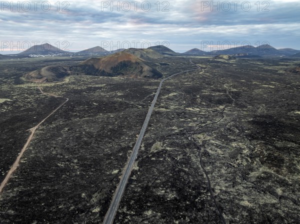Road through lava fields, volcanic landscape with volcanic craters, Los Volcanes Natural Park, aerial view, Lanzarote, Canary Islands, Spain