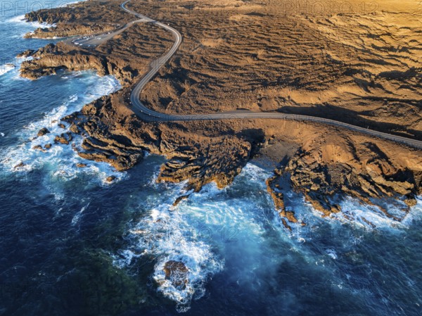 Road on the coast with lava fields, volcanic landscape near Los Hervideros, in the evening light, aerial view, Lanzarote, Canary Islands, Spain