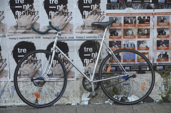 Racing bike set against a wall filled with posters in Odense, Fyn, Funen island, Denmark, Scandinavia