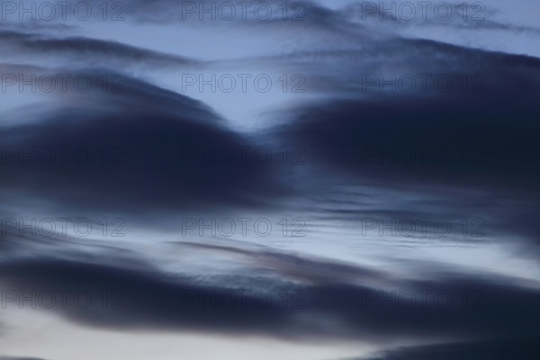 Dark clouds move across a blue-black sky at dusk and create a calm atmosphere, Peenetal nature park Park, Mecklenburg-Western Pomerania, Germany