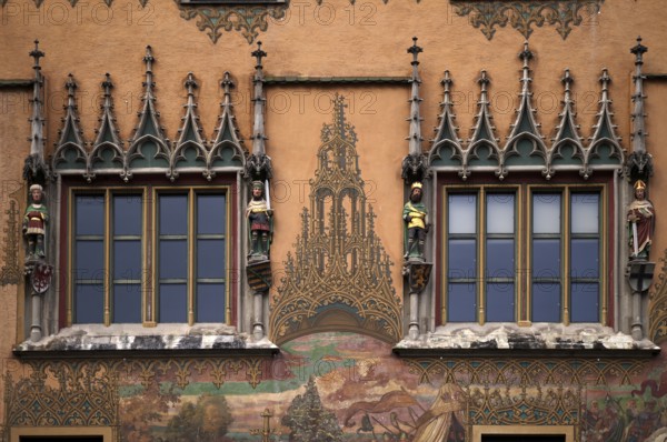 Painted façade with 4 medieval human sculptures, fresco cycle, window, town hall, old town, Ulm, Baden-Württemberg, Germany