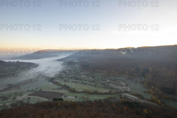Sunrise with fog in the Neidlinger Valley with a view of the Reussenstein castle ruins. Swabian Jura, Baden-Württemberg, Germany
