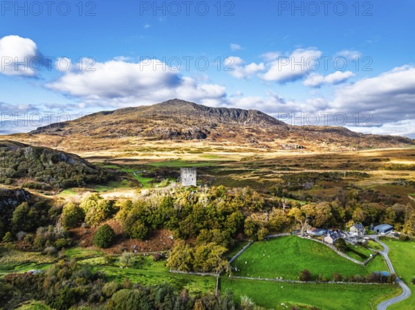 Autumn colours over Castell Dolwyddelan and Eryri Mountains from a drone, Snowdonia, Conwy County Borough, Wales, England, United Kingdom