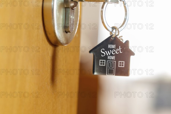 Close-up of a key ring with the inscription HOME SWEET HOME (symbolic image, digitally reworked)