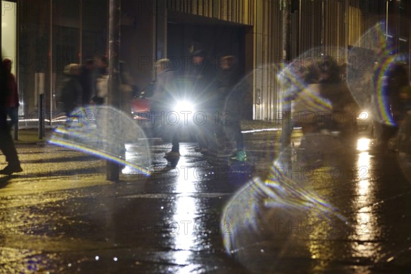 Passers-by in the evening in rainy weather in a city, November, Germany