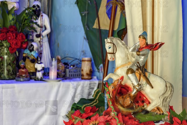Image of Saint George on his horse with an Umbanda altar in the background
