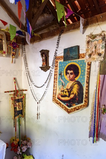 Religious objects inside a simple and rustic house in the interior of Minas Gerais, Brazil with saints and entities from different religions