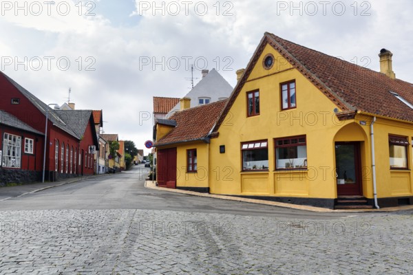Scenic street with colorful houses and cobblestones, Allinge, Bornholm, Denmark