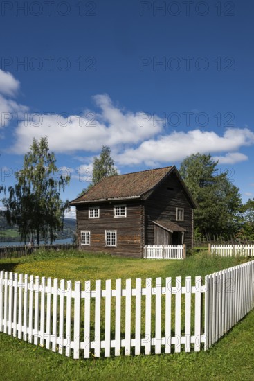 Old farmhouse surrounded by a white-painted fence, Maihaugen open-air museum with houses and objects from farms in Gudbrandsdal, Lillehammer am Mjøsa Lake, Innlandet Fylke Municipality, Norway