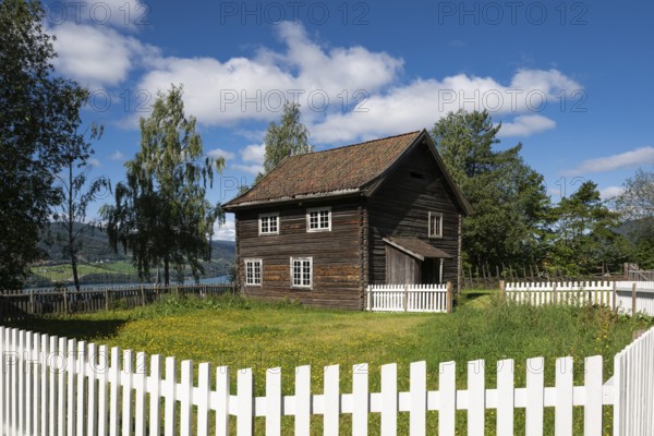 Old farmhouse surrounded by a white-painted fence, Maihaugen open-air museum with houses and objects from farms in Gudbrandsdal, Lillehammer am Mjøsa Lake, Innlandet Fylke Municipality, Norway