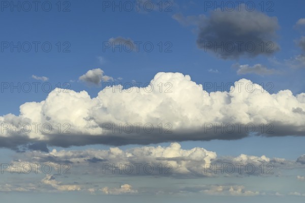 In the center of the image white bright cluster clouds cumulus clouds dense water clouds at the top right single gray cloud under blue sky, international
