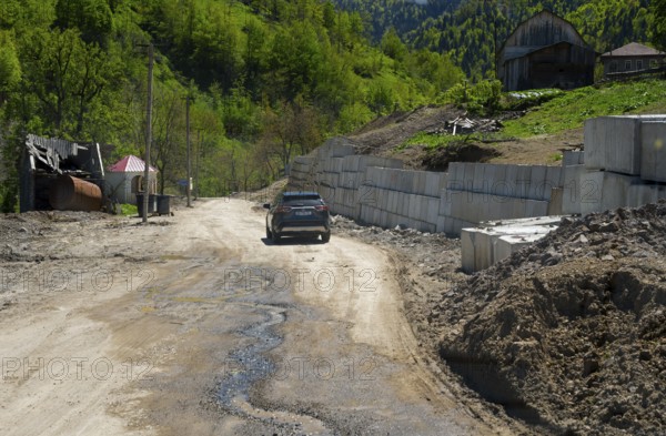 Car drives along a dirt road in a rural mountain landscape, on the way to the Goderdzi Pass near Dioknisi, Ajara region, Ajara, autonomous republic, Georgia