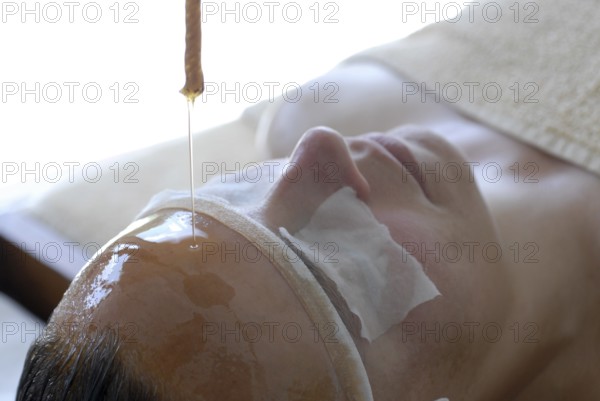 Detail forehead oil glaze or Shirodhara Ayurveda treatment with sesame oil in the spa, Udaipur, Rajasthan, India