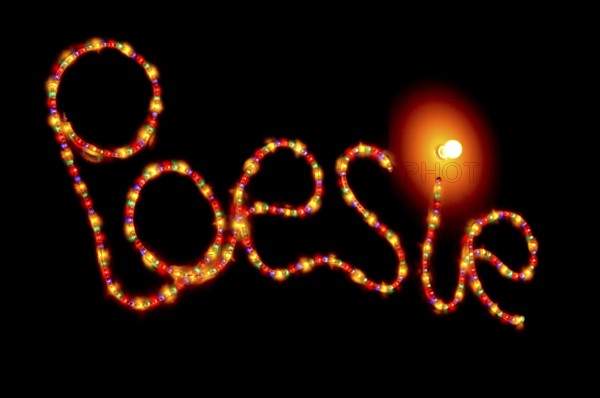 Glowing lettering 'poetry' made of colorful lights on black background, warm atmosphere, Germany