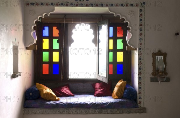 Cosy sitting area with colorful window and pillows, traditional style and cozy atmosphere, Palasthotel Karni Fort Bambora, Bambora, Rajasthan, India