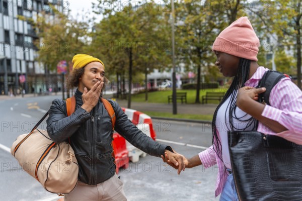 Young diverse couple holding hands while walking on an urban street, exploring the city together with bags and backpacks, representing travel and relationship