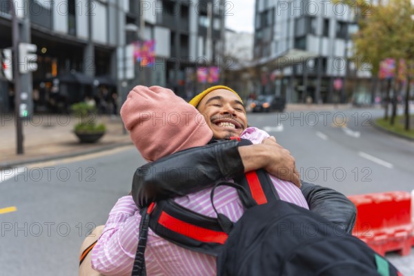 Enthusiastic young men sharing a warm embrace and smiling sincerely during a happy reunion on an urban street, celebrating their friendship and connection