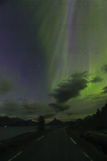 Road in the northern lights at dawn over Sørfolda Fjord near Kjerringøy between Bodø and Sørfold in Norway