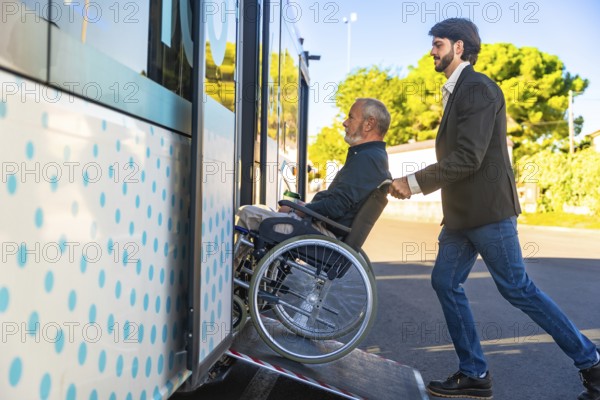 Young man assisting an elderly person using a wheelchair to board a public transport bus via an accessibility ramp, highlighting concepts of care, mobility, and community support