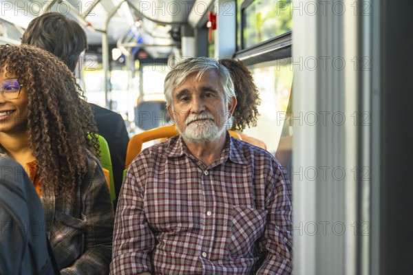 Senior man with a gray beard and plaid shirt sitting on a public bus, commuting with other diverse passengers during the day, representing city life and urban transportation