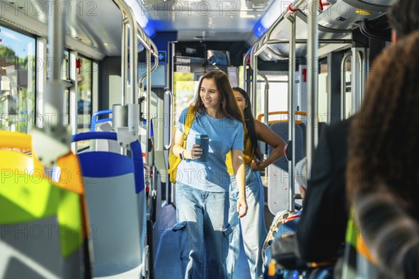 Young woman passenger holding a reusable coffee cup and backpack, walking through the aisle of a public bus on a sunny day, representing sustainable transportation and urban commute