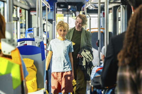 Mother and son traveling together inside a modern public transport bus, enjoying a casual family outing or daily commute, highlighting sustainable urban mobility and shared travel experiences