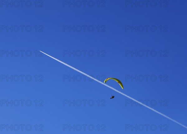 Paragliders with contrails in the blue sky, Osterhorn Group, Salzkammergut, Province of Salzburg, Austria