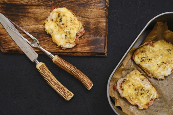 Succulent pork chops are baked to perfection in an air-fryer, topped with melted cheese, and displayed on a wooden cutting board alongside a serving dish
