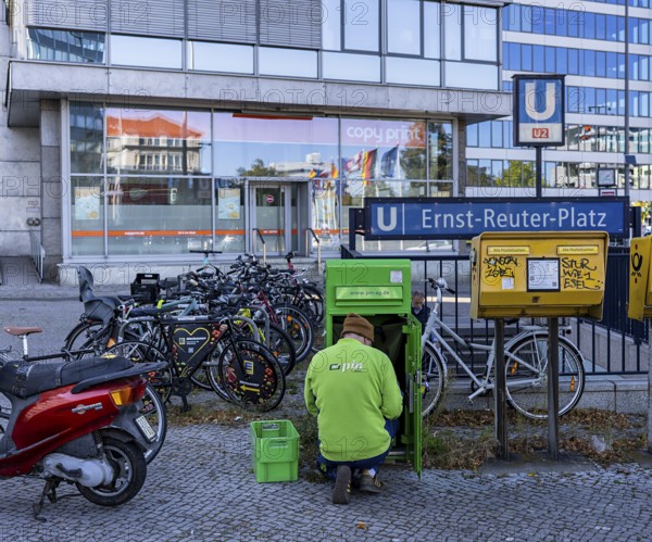 Pin Ag employees at a green mailbox in front of the subway entrance at Ernst Reuter Platz, Berlin, Germany