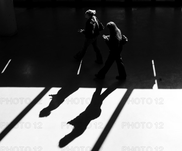 Black and white photograph, foyer in a building at the Technical University of Berlin, light and shadow of people at the Marchstraße exit, Berlin, Germany