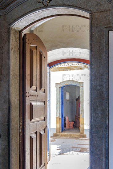Open Baroque church door overlooking the courtyard and entrance to a chapel in Congonhas