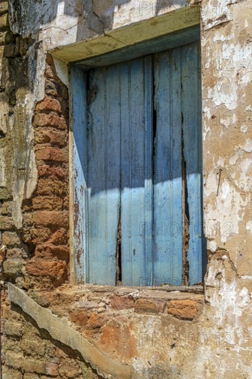 Wooden window and wall of an old, abandoned house, destroyed by time