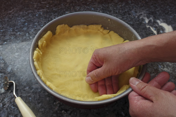 Southern German cuisine, preparation shortcrust pastry, put raw dough in the baking pan, press firmly, countertop, making cake, baking, out of the oven, vegetarian, traditional cuisine, men's hands, food photography, studio, Germany