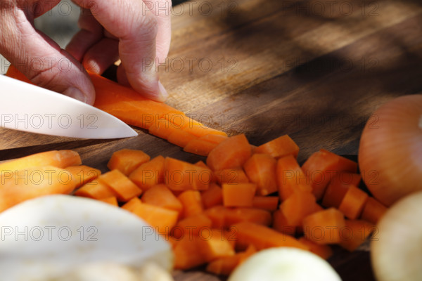 Southern German cuisine, preparing vegetables, cutting raw carrots, celery, onions, vegetarian, vegan, healthy, knife, cutting board, men's hand, traditional cuisine, food photography, studio, Germany