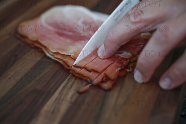 Southern German cuisine, Black Forest ham, smoked, meat, cutting, kitchen knife, wooden board, preparation, cutting board, men's hand, traditional cuisine, food photography, studio, Germany