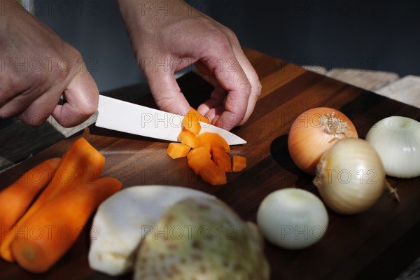 Southern German cuisine, preparing vegetables, cutting raw carrots, celery, onions, vegetarian, vegan, healthy, knife, cutting board, men's hands, traditional cuisine, food photography, studio, Germany