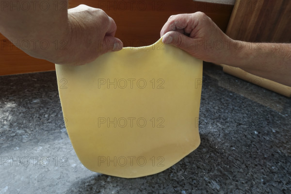 Swabian cuisine, preparing strudel dough, removing raw potato dough, countertop, baking, out of the oven, dough roll, men's hands, typical Swabian, traditional cuisine, food photography, studio, Germany