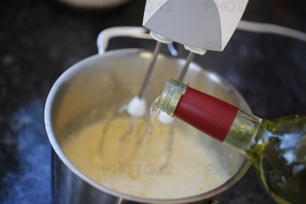 Southern German cuisine, preparation of wine cream, dessert, dessert, dessert, pouring white wine into mass, cooking pot, wine bottle, food photography, studio, Germany