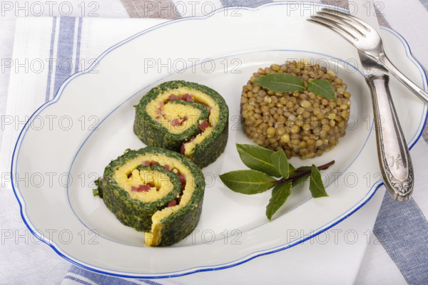 Southern German cuisine, polenta spinach roulade with alblentils served on serving platter, bay leaves, lentil vegetables, smoked meat, bacon cubes, healthy, food photography, studio, Germany