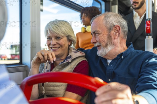 Senior husband and wife smiling and chatting on a daytime city bus, enjoying public transport together on a relaxed outing, comfortable, content, and engaged with each other