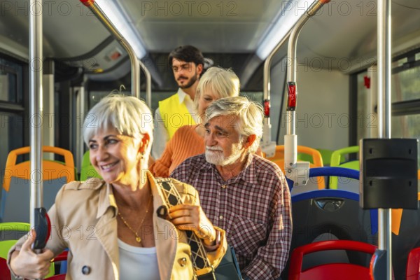 Seniors with gray hair and a younger man riding a modern public bus, holding onto vertical poles while commuting and looking around during their journey