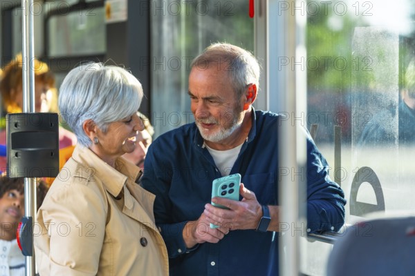 Senior couple standing on a city bus, smiling and sharing a smartphone as they browse together, enjoying public transport, conversation and modern connection on their journey