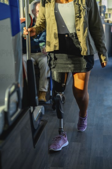 Woman with prosthetic leg and athletic shoe standing on a city bus, holding the handrail while commuting symbolizing mobility, independence, inclusion and urban accessibility
