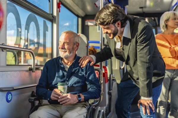 Young man offering support and kindness to a smiling senior passenger using a wheelchair, showcasing empathy and accessibility during their journey on a bus